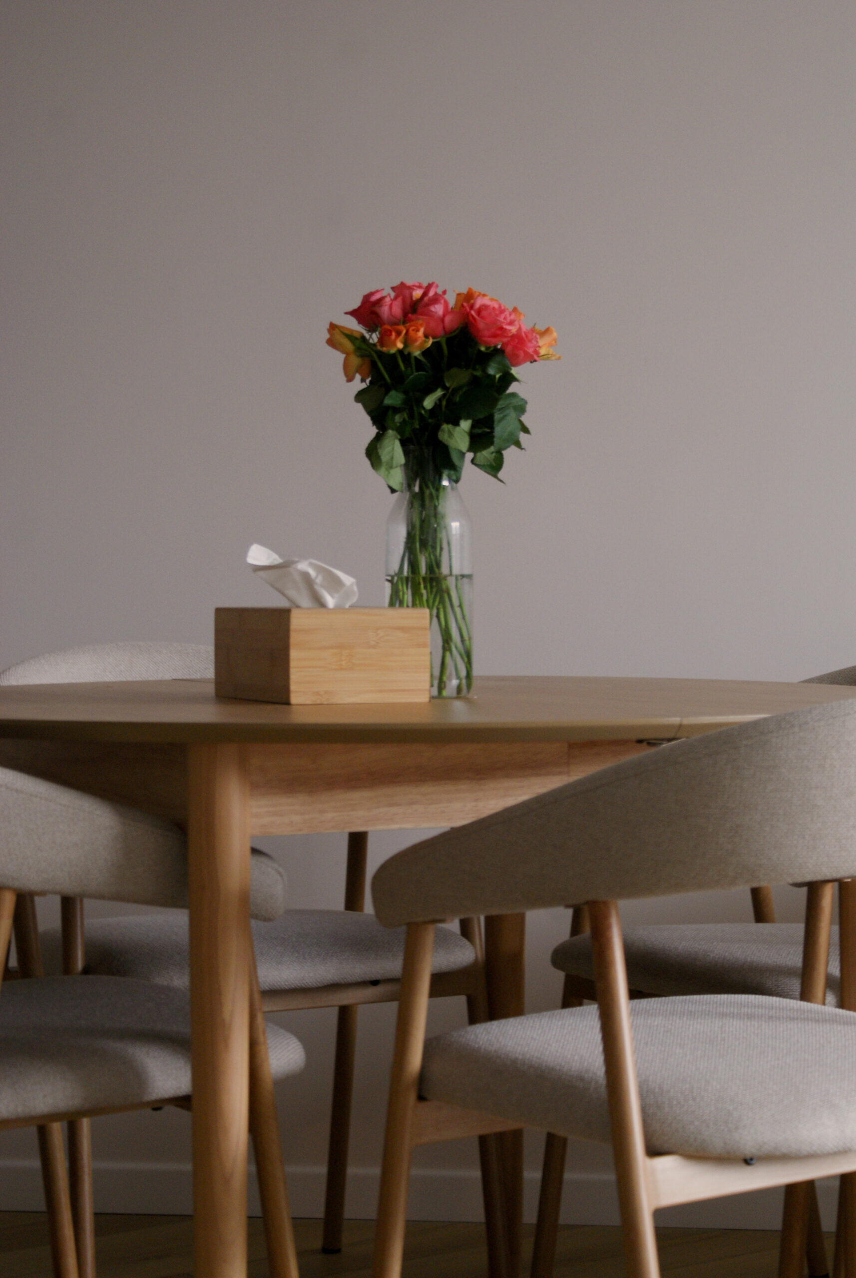 Strefa jadalniana w małym mieszkaniu. Drewniany okrągły stół i krzesła na tle jasnych ścian. Wykończenie pod klucz Kraków.